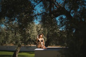 woman sitting on pools side with hat