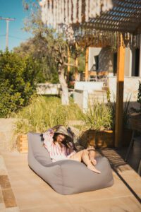 woman with hat relaxing in outdoor sofa